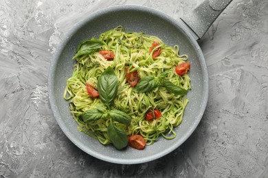 Photo of Tasty zucchini noodles with tomatoes and basil, top view