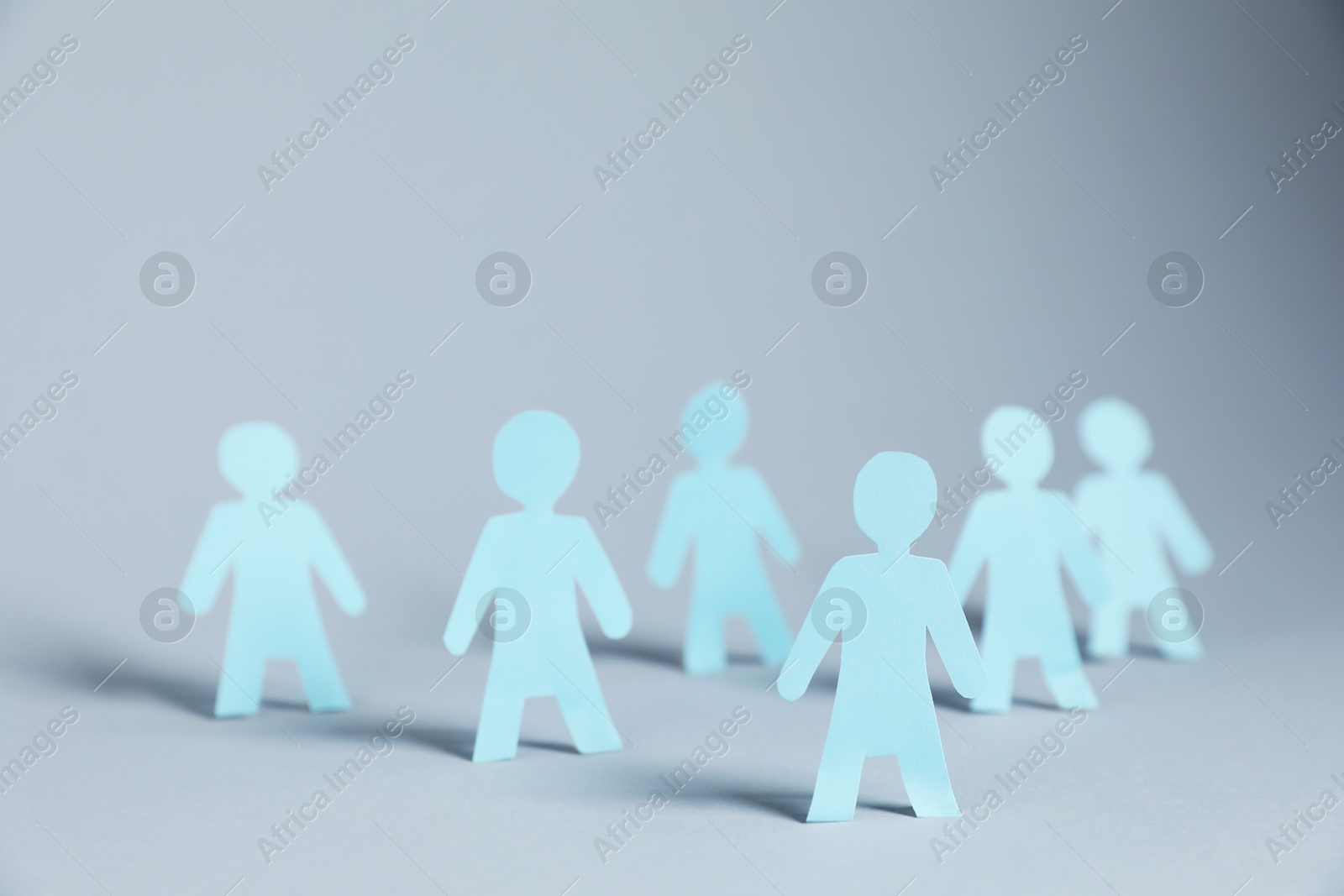 Many human paper figures on light background Photo of Many human paper figures on light background