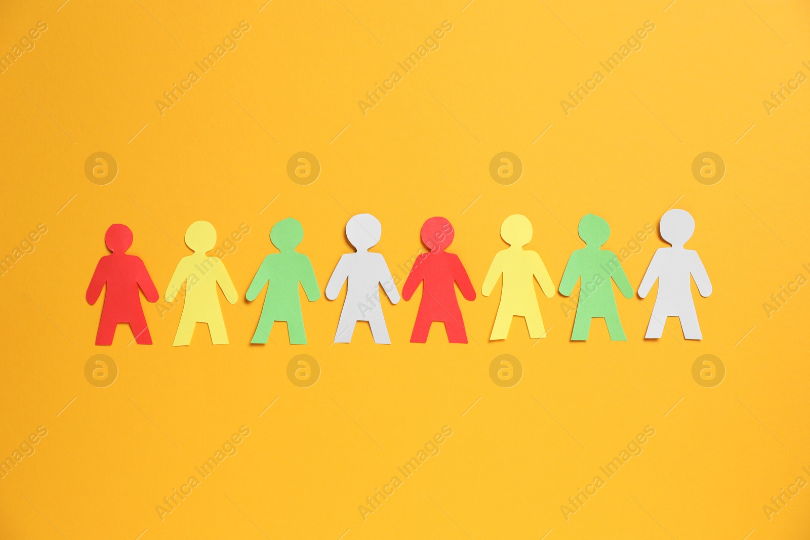 Many human paper figures on orange background, flat lay Photo of Many human paper figures on orange background, flat lay