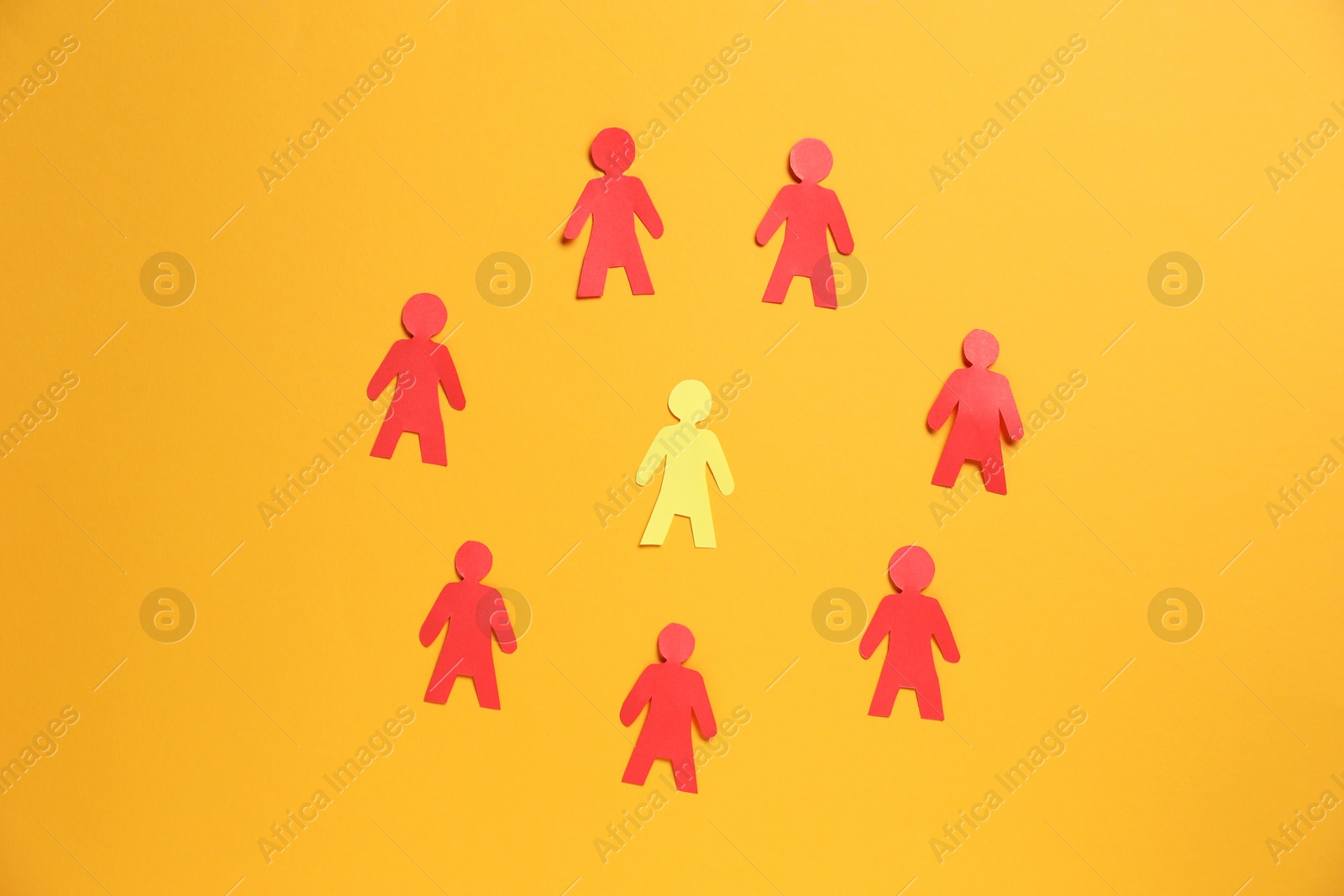 Many human paper figures on orange background, flat lay Photo of Many human paper figures on orange background, flat lay
