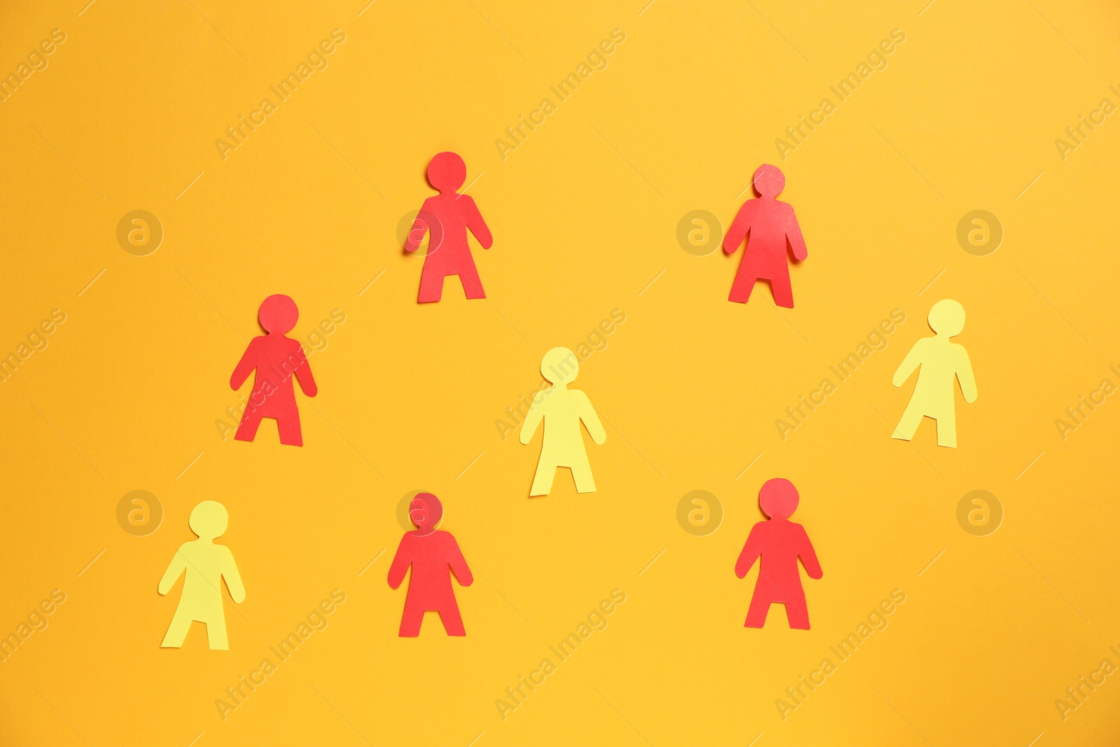 Many human paper figures on orange background, flat lay Photo of Many human paper figures on orange background, flat lay