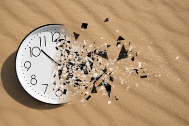 Image of Time running out. Clock dissolving on sand