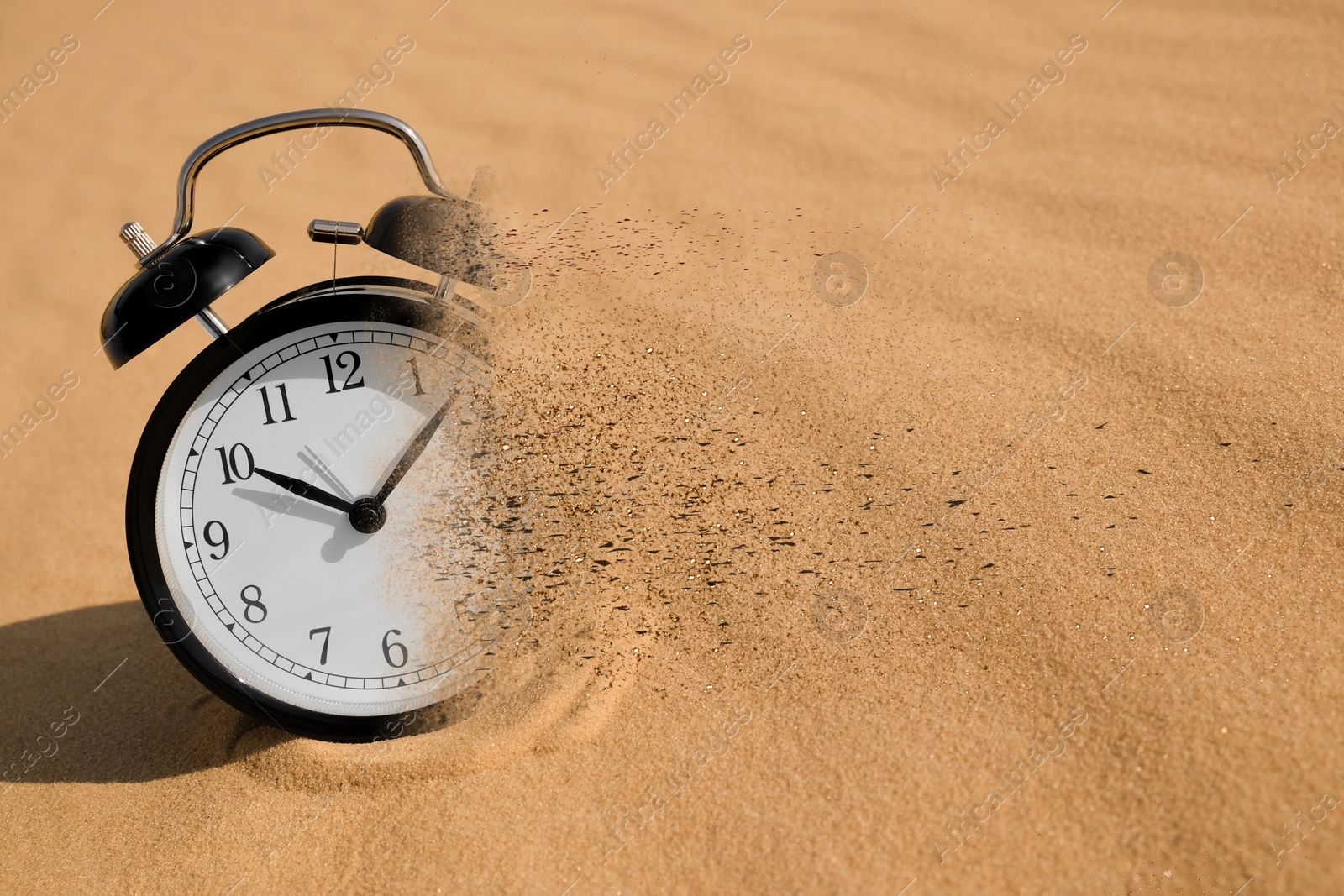Time running out. Black alarm clock dissolving in sand Image of Time running out. Black alarm clock dissolving in sand