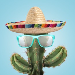 Image of Cactus with sunglasses and sombrero hat against light blue background