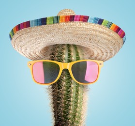 Image of Cactus with sunglasses and sombrero hat against light blue background