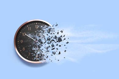 Image of Time running out. Clock dissolving on light blue background