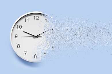 Image of Time running out. Clock dissolving on light blue background