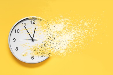 Image of Time running out. Clock dissolving on orange background