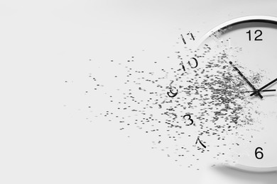 Image of Time running out. Clock dissolving on white background