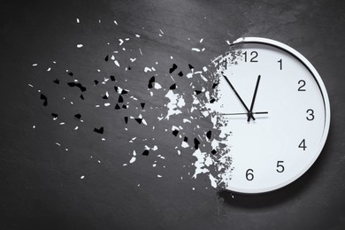 Image of Time running out. Clock dissolving on grey textured background