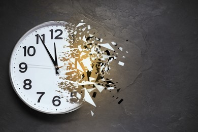 Image of Time running out. Clock dissolving on grey textured background