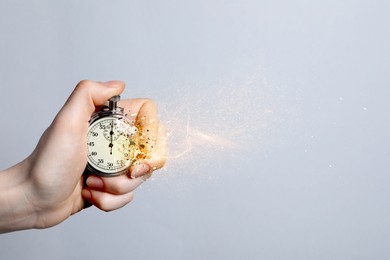 Image of Time running out. Pocket watch dissolving in woman's hand against white background, closeup