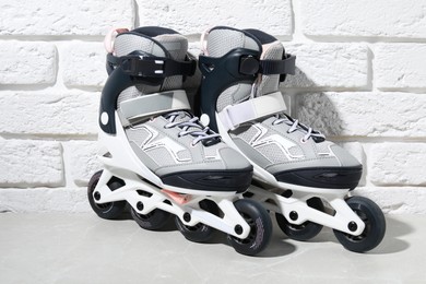 Photo of Pair of roller skates on grey marble table near white brick wall