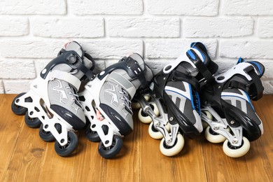 Photo of Roller skates on wooden table near white brick wall, above view