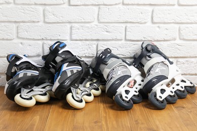 Photo of Roller skates on wooden table near white brick wall