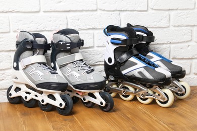 Photo of Roller skates on wooden table near white brick wall
