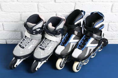 Photo of Roller skates on blue table near white brick wall, above view