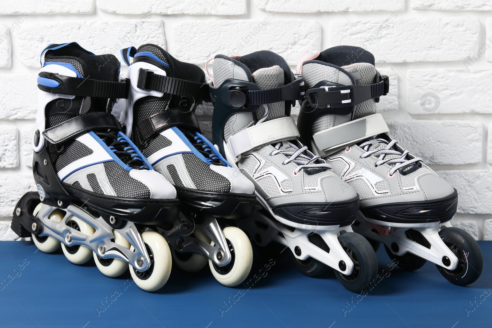 Photo of Roller skates on blue table near white brick wall