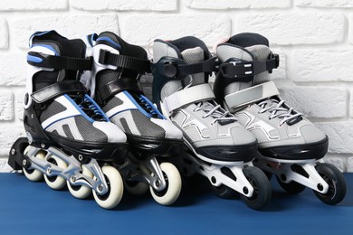 Photo of Roller skates on blue table near white brick wall