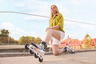 Photo of Happy woman with roller skates on street, selective focus