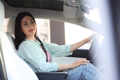 Photo of Woman holding steering wheel while driving car, view from outside