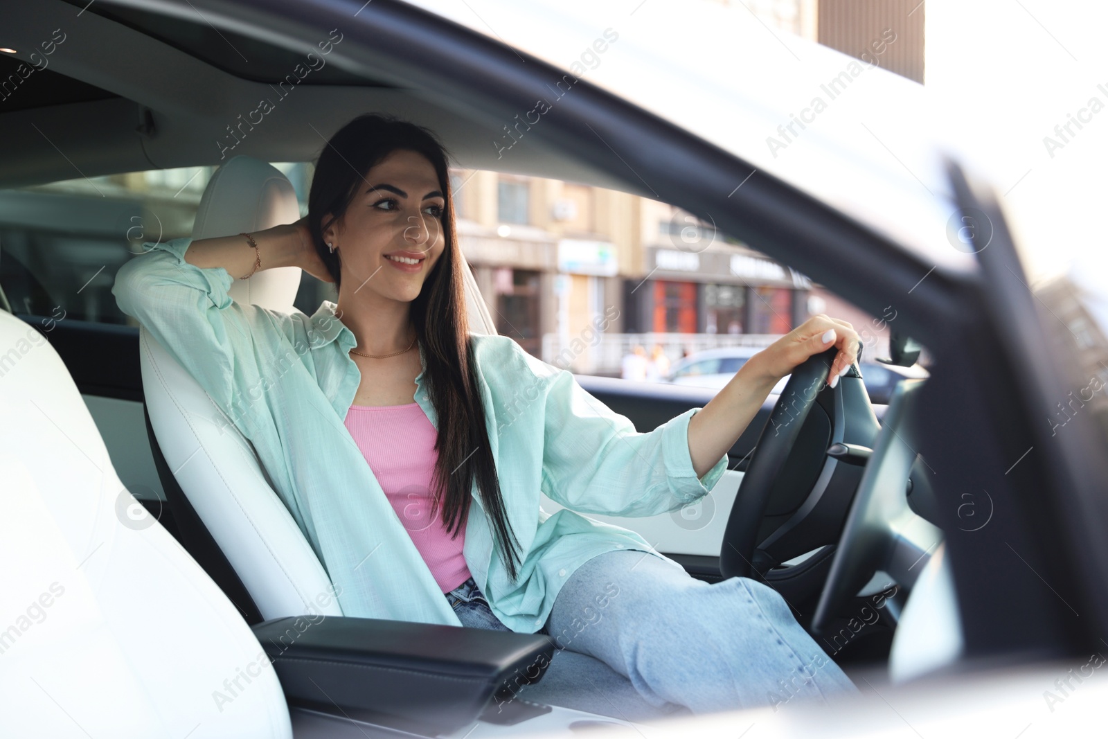 Photo of Woman holding steering wheel while driving car, view from outside