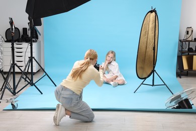 Photo of Photographer working with model in professional photo studio