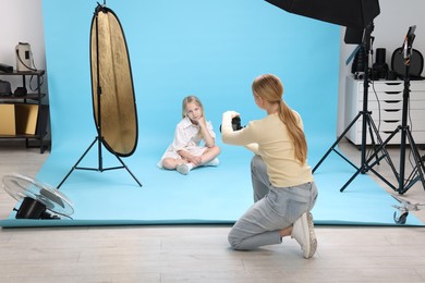 Photo of Photographer working with model in professional photo studio