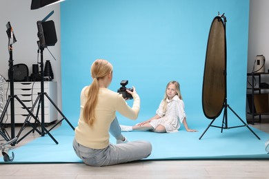 Photo of Photographer working with model in professional photo studio