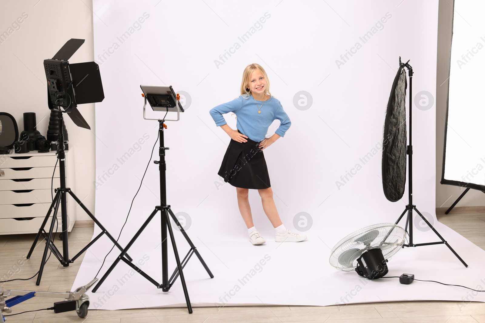Little girl on white background in photo studio with professional equipment Photo of Little girl on white background in photo studio with professional equipment