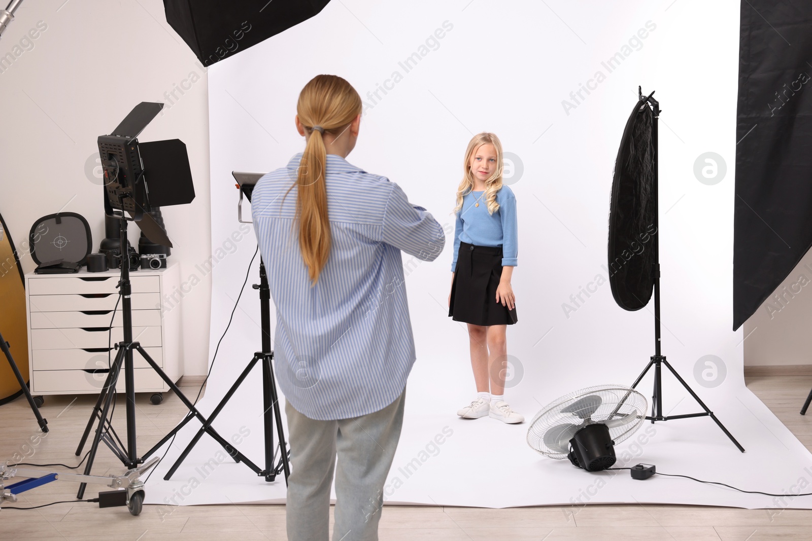 Photo of Photographer working with model in professional photo studio