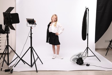 Photo of Little girl on white background in photo studio with professional equipment