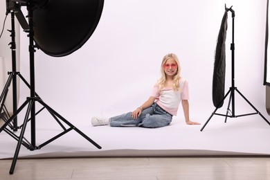Photo of Little girl on white background in photo studio with professional equipment