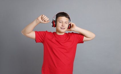 Photo of Teenage boy in headphones on grey background