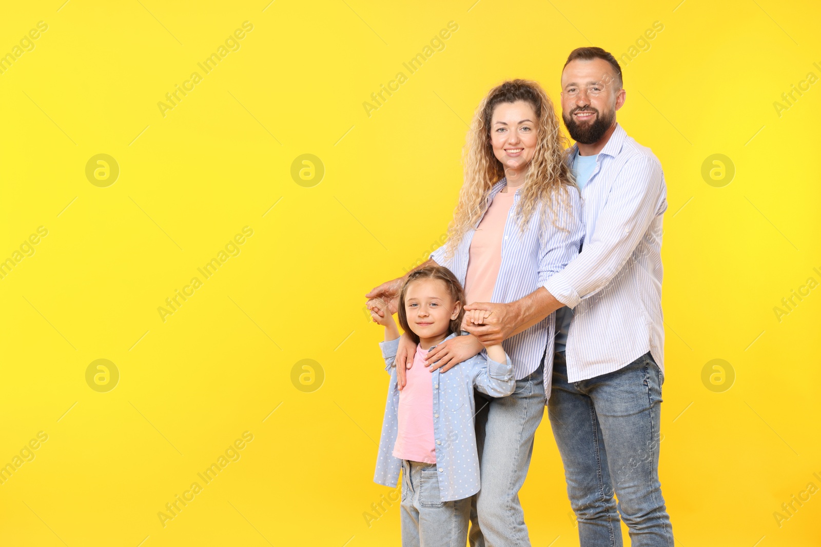 Photo of Portrait of happy family on yellow background. Space for text