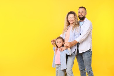 Photo of Portrait of happy family on yellow background. Space for text