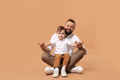 Photo of Family. Happy father and his son on beige background