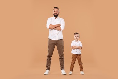 Photo of Family. Happy father and his son posing on beige background