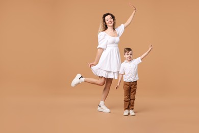 Photo of Family. Happy mother and her son posing on beige background. Space for text