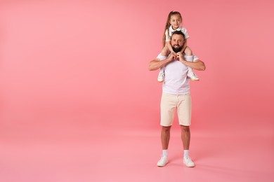 Photo of Family. Happy father and his daughter on pink background. Space for text