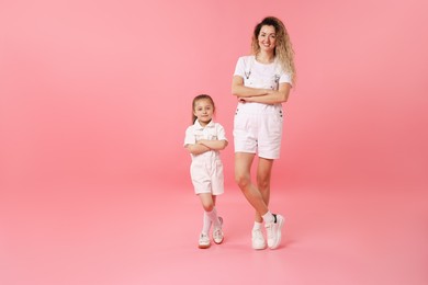 Photo of Family. Happy mother and her daughter posing on pink background