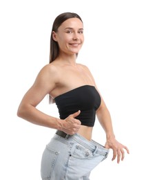 Photo of Fit woman wearing old jeans after weight loss and showing thumbs up on white background