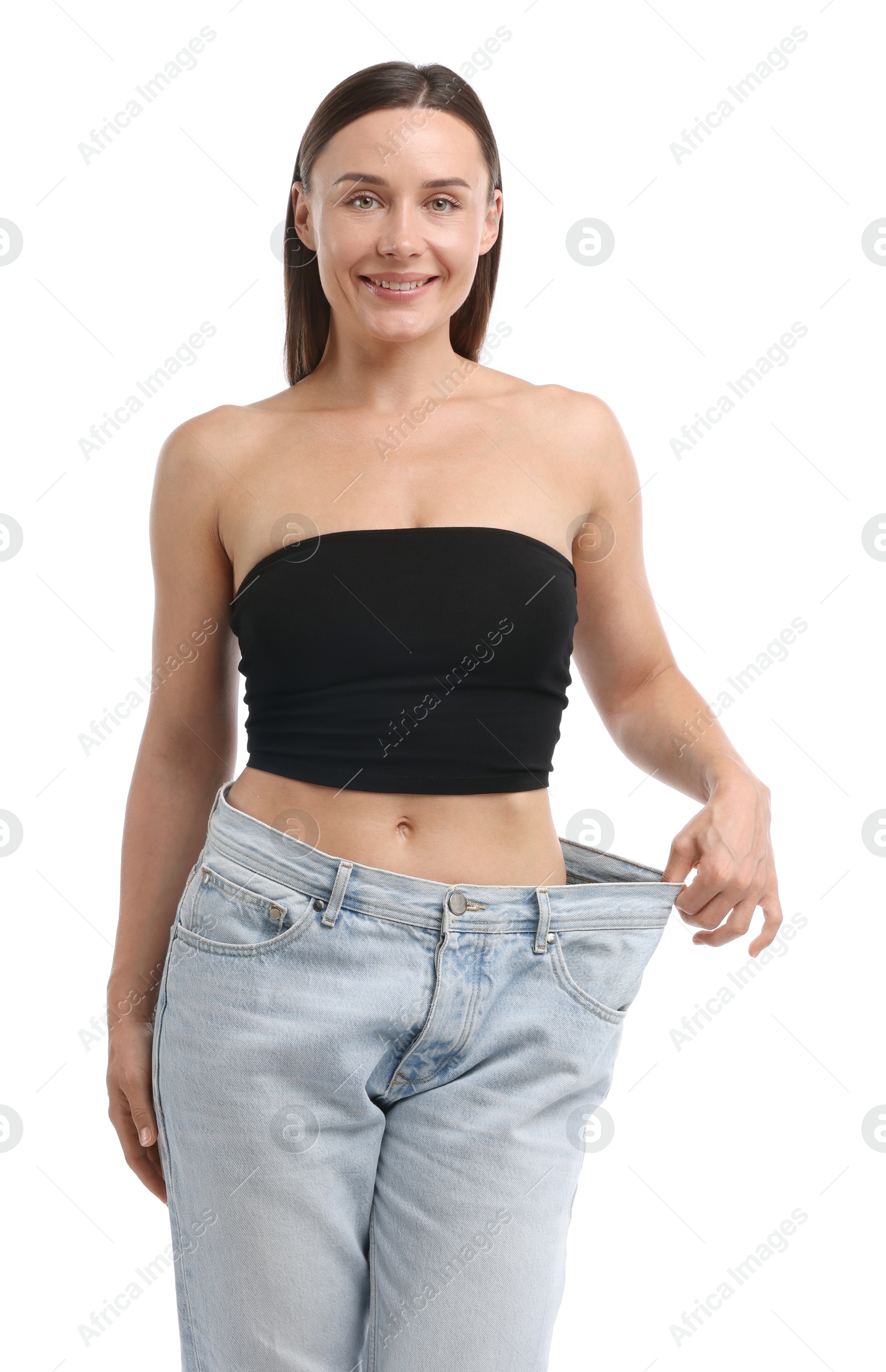 Fit woman wearing old jeans after weight loss on white background Photo of Fit woman wearing old jeans after weight loss on white background