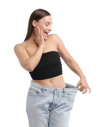 Photo of Excited woman wearing old jeans after weight loss on white background