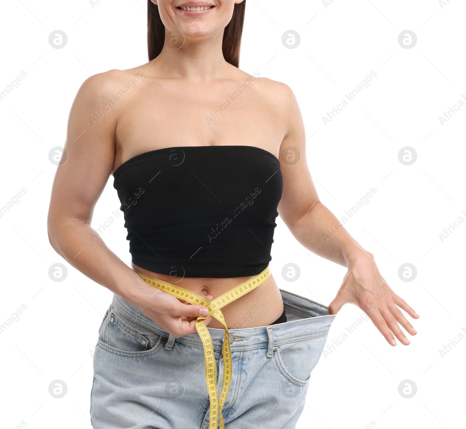 Fit woman with measuring tape wearing old jeans after weight loss on white background, closeup Photo of Fit woman with measuring tape wearing old jeans after weight loss on white background, closeup