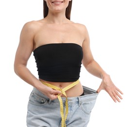 Photo of Fit woman with measuring tape wearing old jeans after weight loss on white background, closeup