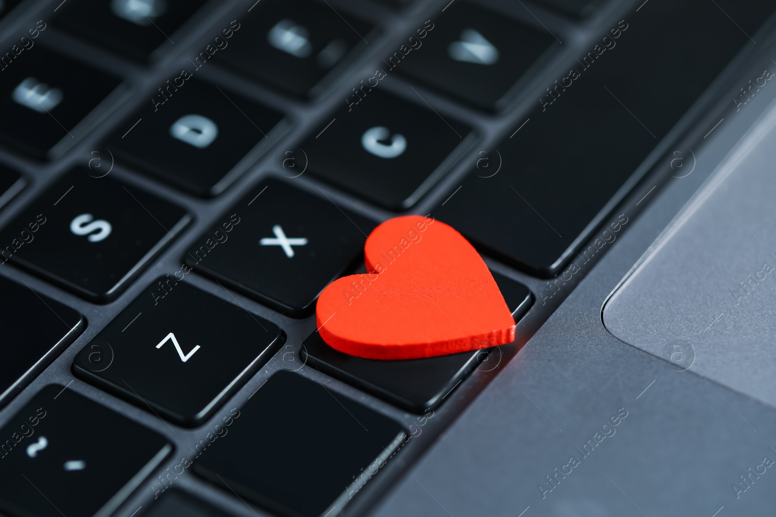Decorative heart on laptop, closeup. Online dating site Photo of Decorative heart on laptop, closeup. Online dating site