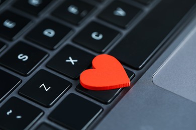 Photo of Decorative heart on laptop, closeup. Online dating site
