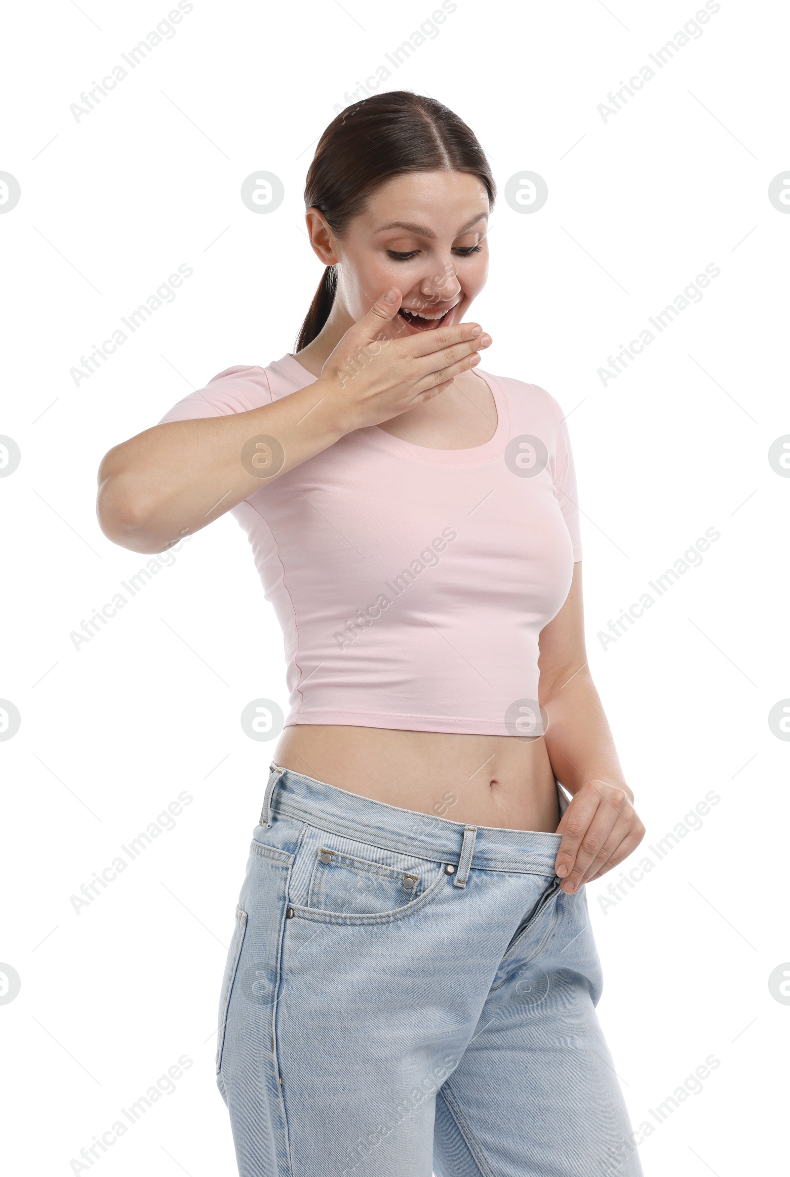 Photo of Beautiful woman wearing old jeans after weight loss on white background