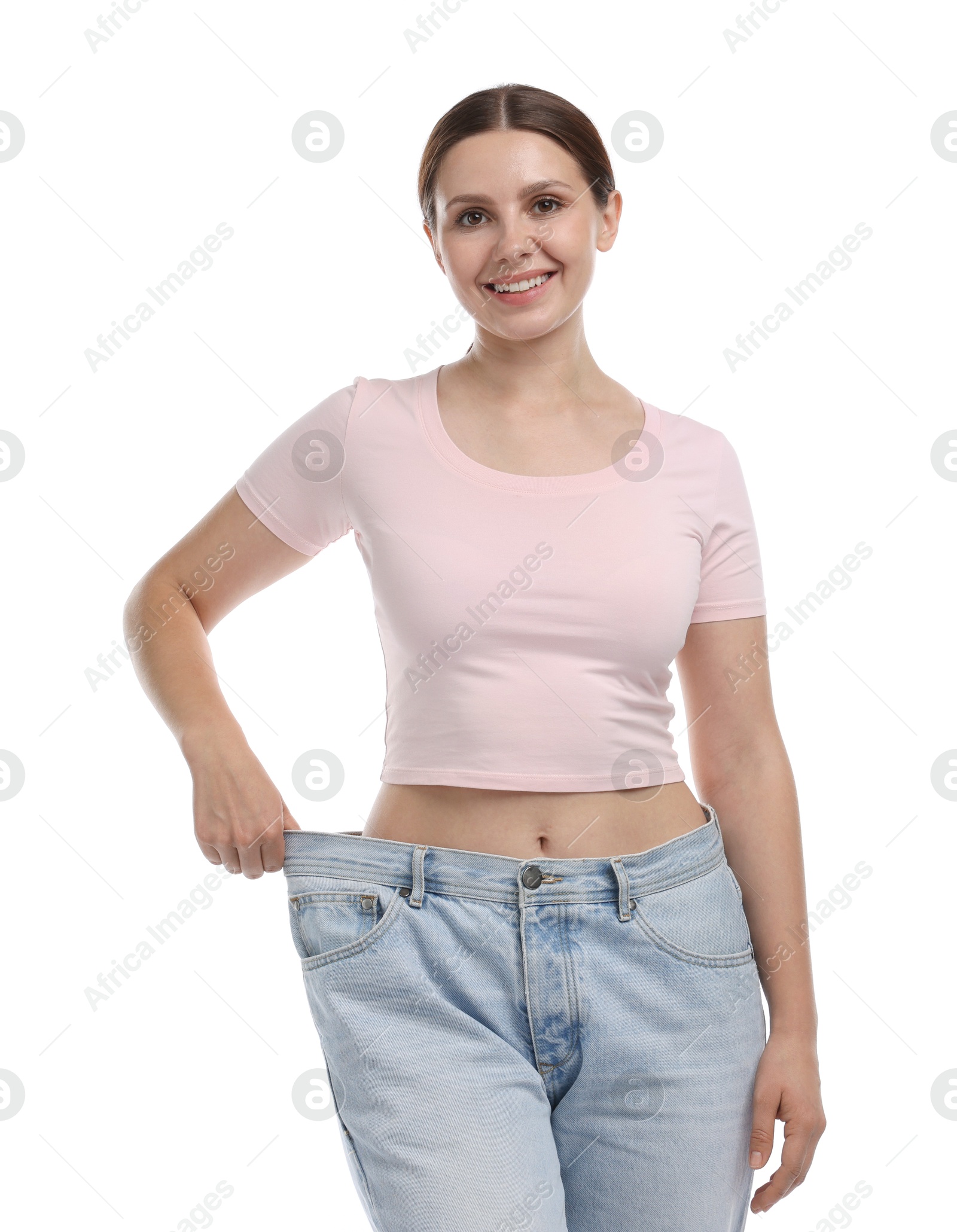 Photo of Beautiful woman wearing old jeans after weight loss on white background